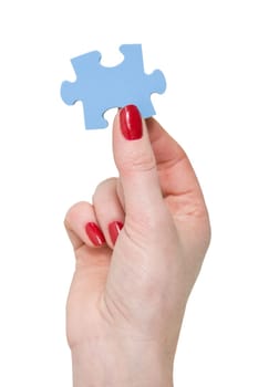 female hand with a piece of blue puzzle
