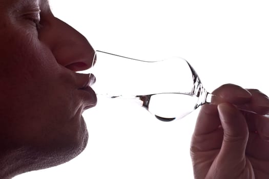 Man drinking a grappa from a grappa glass