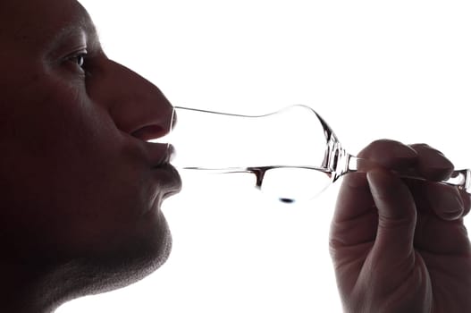 A man drinks a grappa from a grappa glass