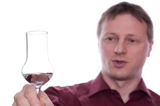 A drunk man raises his glass of liquor