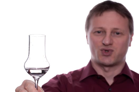 A man holds a glass of fruit brandy in front