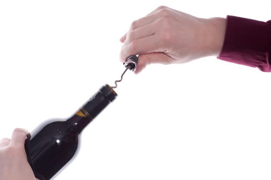 A hand twists a waiter's knife into the cork,a bottle of red wine