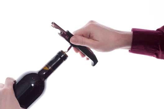 Corkscrew is turned by hand into a cork of a wine bottle