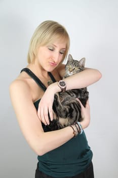 A gril holds a young cat in her hands