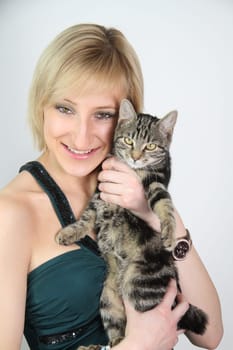 A gril holds a young cat in her hands