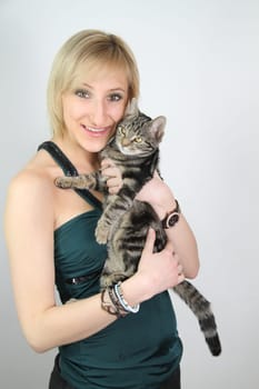 A gril holds a young cat in her hands