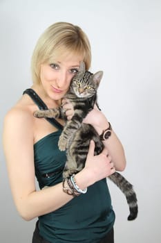 A gril holds a young cat in her hands