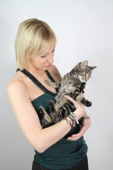 A gril holds a young cat in her hands