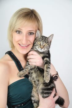 A gril holds a young cat in her hands