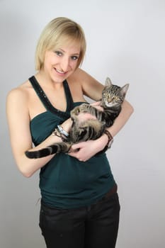 A gril holds a young cat in her hands