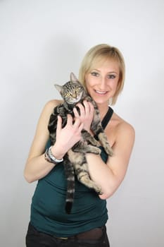 A gril holds a young cat in her hands