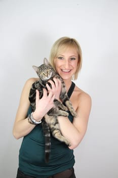 A gril holds a young cat in her hands