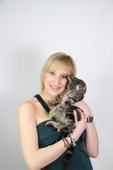 A gril holds a young cat in her hands
