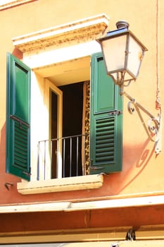 decorative window with a lantern on a house façade in Italy