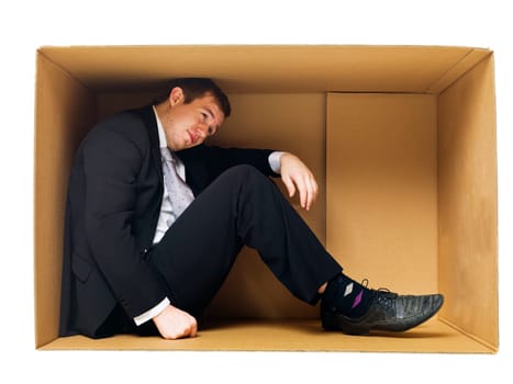 Businessman in a tight cardboard box isolated on white background