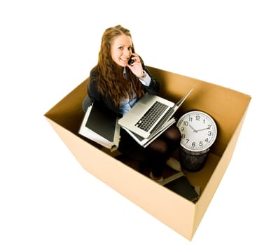 Businesswoman in a very small Cardboard Office isolated on white background
