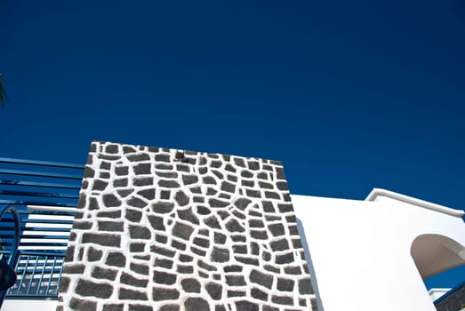 An Abstract Wall of Volcanic Stone against a blue sky