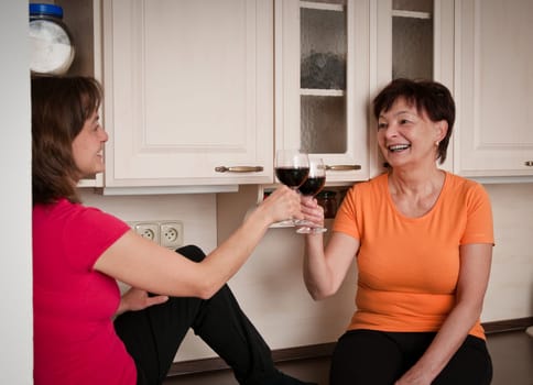 Happy life - mother and daughter drinking wine