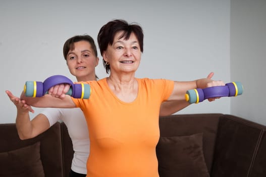 Senior woman exercising with trainer