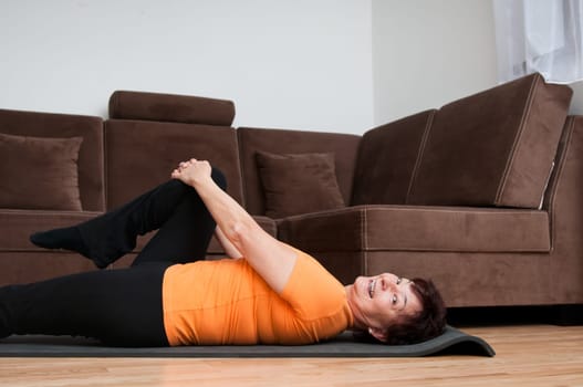 Mature fitness woman exercising at home