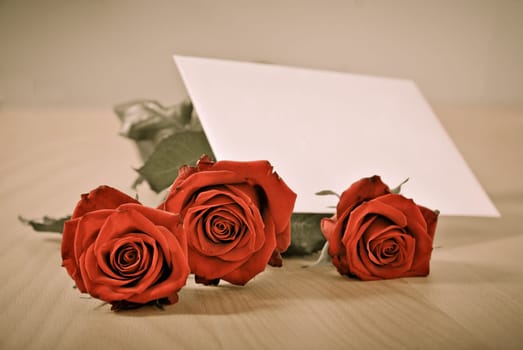 Love message on table - red roses with envelope