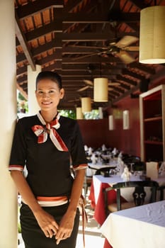 Portrait of attractive young asian woman working as waitress in exclusive restaurant. Waist up, front view