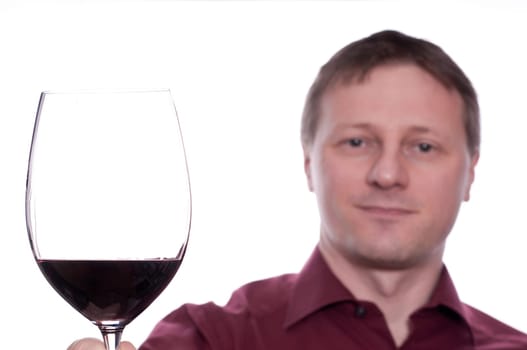 A smiling man toasts with a glass of red wine