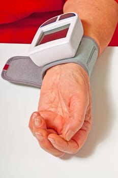 Senior citizen measures blood pressure