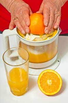 Senior citizen squeezes orange juice