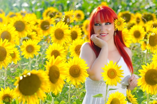 A pretty woman on blooming sunflower field in summer
