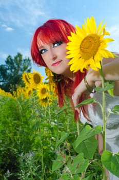 Young woman on blooming sunflower field in summer