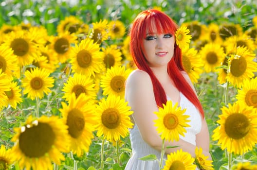 A beautiful red haired woman with sunflowers