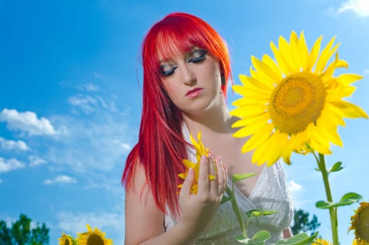 A young woman is playing with sunflower
