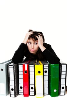 Stressed female office worker with folders. Studio shot, isolated on white background