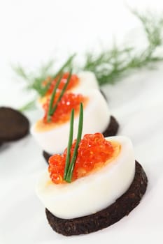 Canapes with boiled egg and caviar