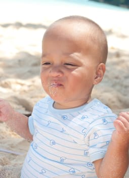 baby playing with sand on a tropical beach