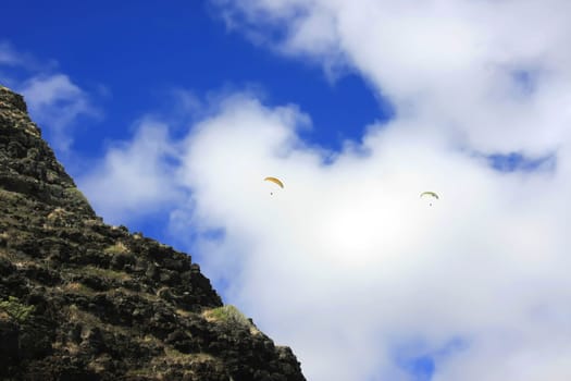 Two paragliders on a mountainside