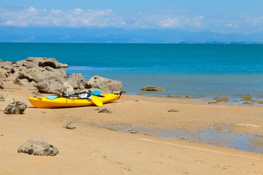 Yellow sea kayak on the beach on Tasman Bay in New Zealand