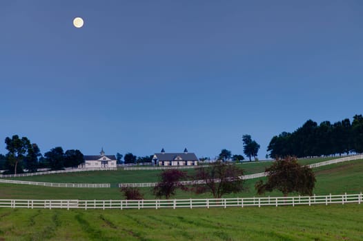 Night scene with the moon rising over a horse farm in Central Kentucky