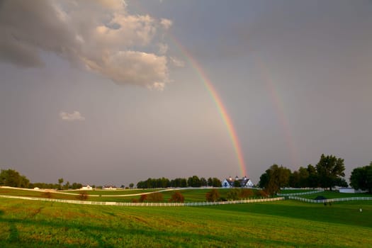 Scenic view of a horse farm after storm with double rainbow