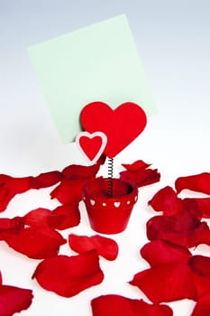 Devil and the heart-shaped flower with a note attached to the rhyme standing among the petals of roses