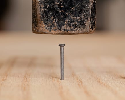 Nail being driven into wood by hammer head