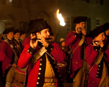 WILLIAMSBURG, VIRGINIA - DECEMBER 29: Marching soldiers at night on December 29, 2011. Colonial Williamsburg&#039 s 301 acres includes many restored buildings and houses and hosts re-enactments.
