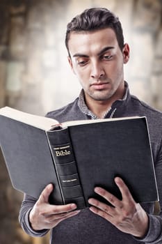 Portrait of a young man reading the Holy Bible