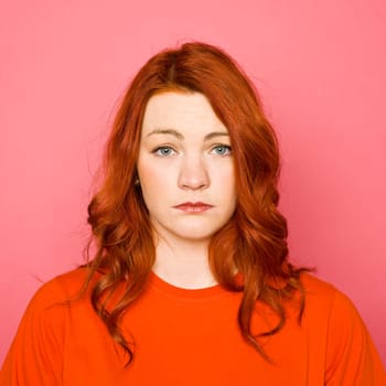 Woman with red hair on pink background