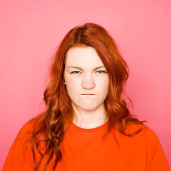 Woman with red hair on pink background