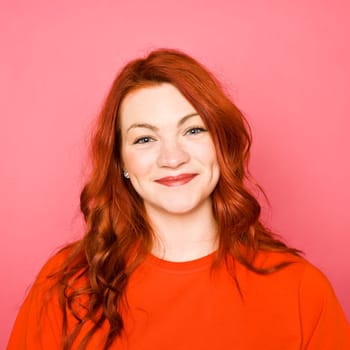 Woman with red hair on pink background