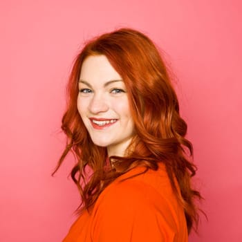 Woman with red hair on pink background