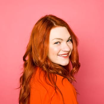 Woman with red hair on pink background