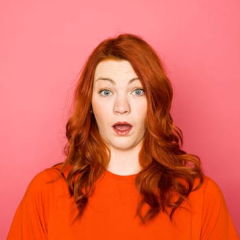 Woman with red hair on pink background